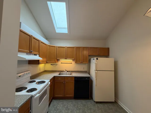a kitchen with a refrigerator a stove a sink dishwasher and cabinets