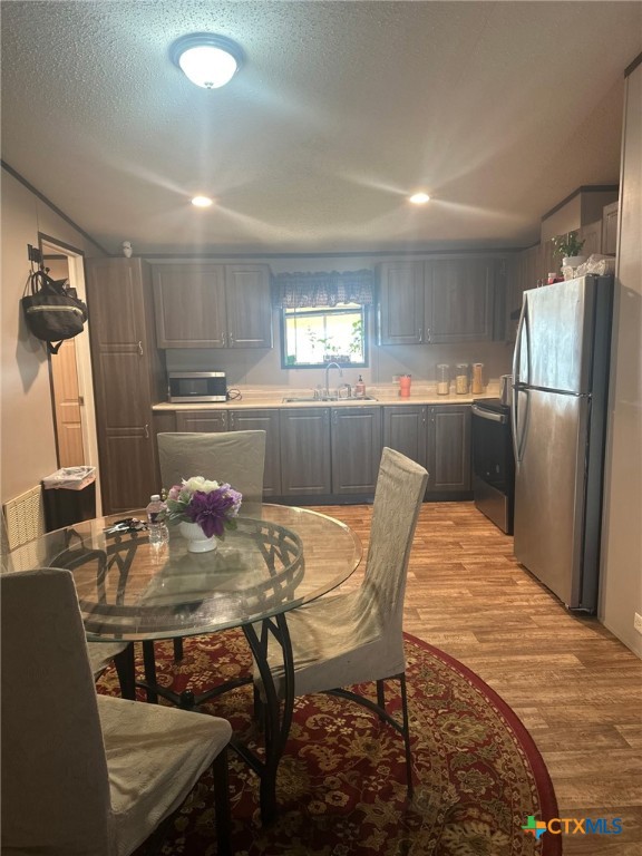 849 Rustler Pass Kyle, TX 78640 - Photo 4 of 10 a kitchen with stainless steel appliances granite countertop a dining table chairs and refrigerator