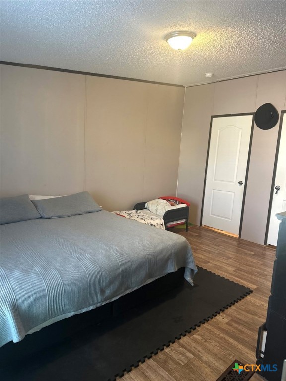 849 Rustler Pass Kyle, TX 78640 - Photo 6 of 10 a bedroom with a bed and wooden floor