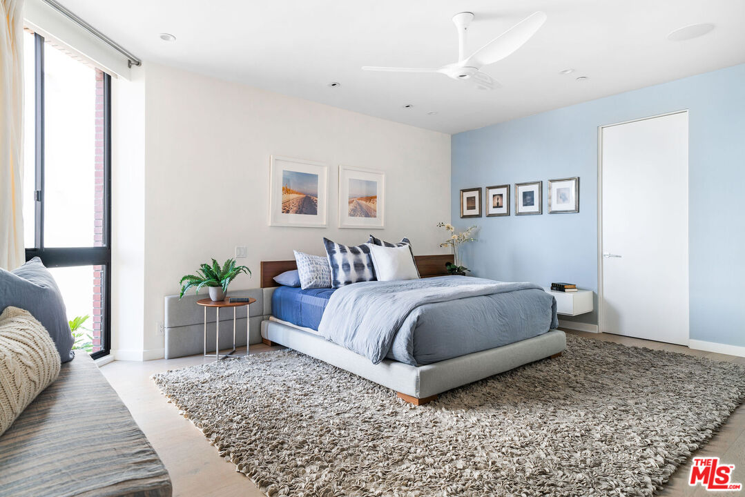 1033 Ocean Avenue, Unit 104 Santa Monica, CA 90403 - Photo 12 of 26 a bedroom with a bed rug and a window