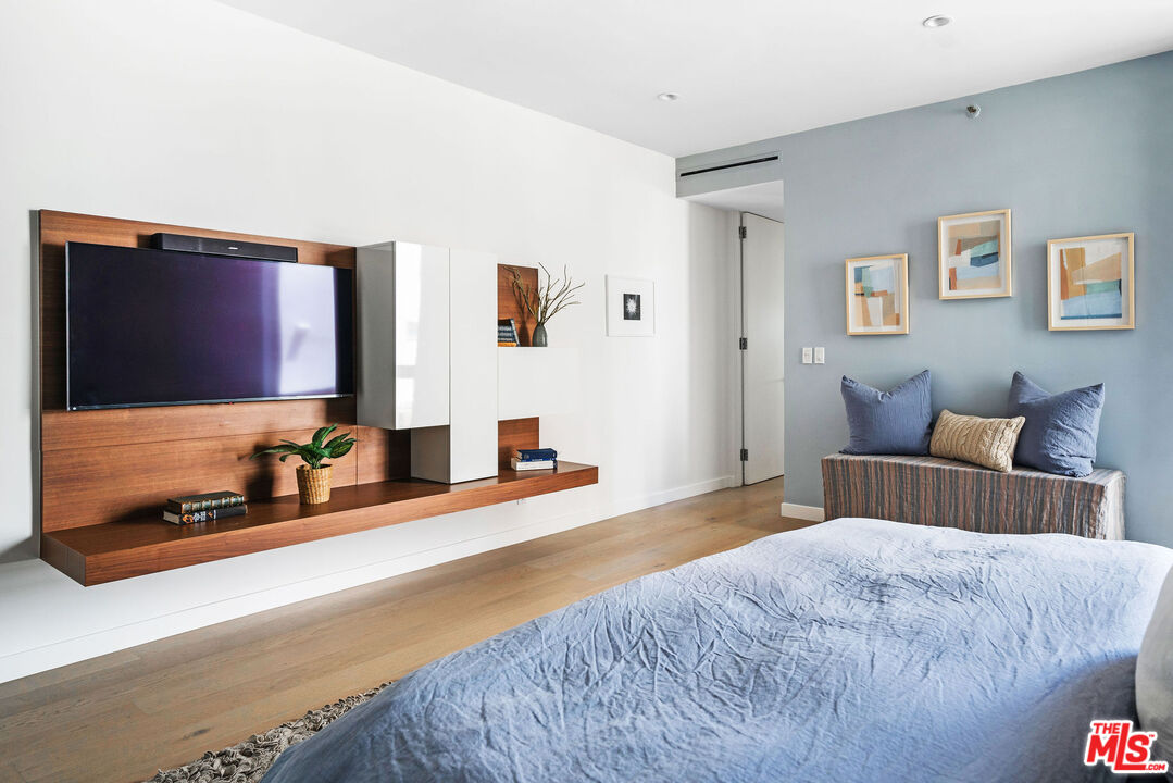 1033 Ocean Avenue, Unit 104 Santa Monica, CA 90403 - Photo 13 of 26 a bedroom with a bed and a flat screen tv