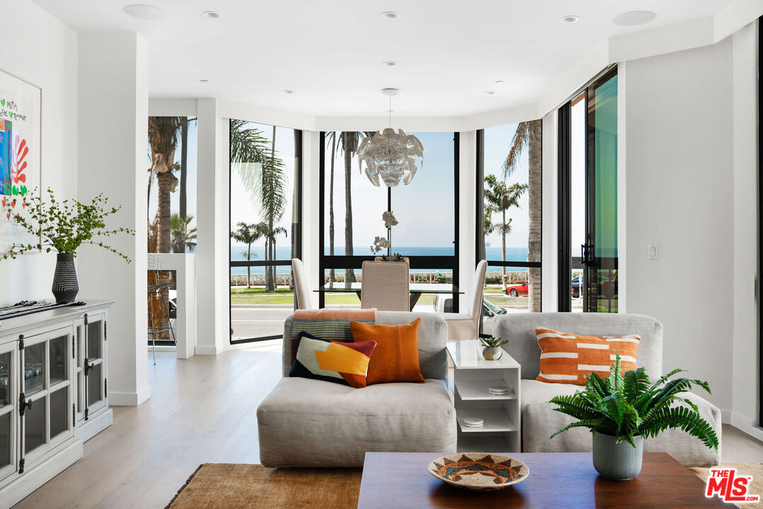 1033 Ocean Avenue, Unit 104 Santa Monica, CA 90403 - Photo 2 of 26 a living room with furniture potted plant floor to ceiling windows and a flat screen tv