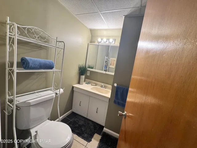 a bathroom with a granite countertop toilet sink and mirror
