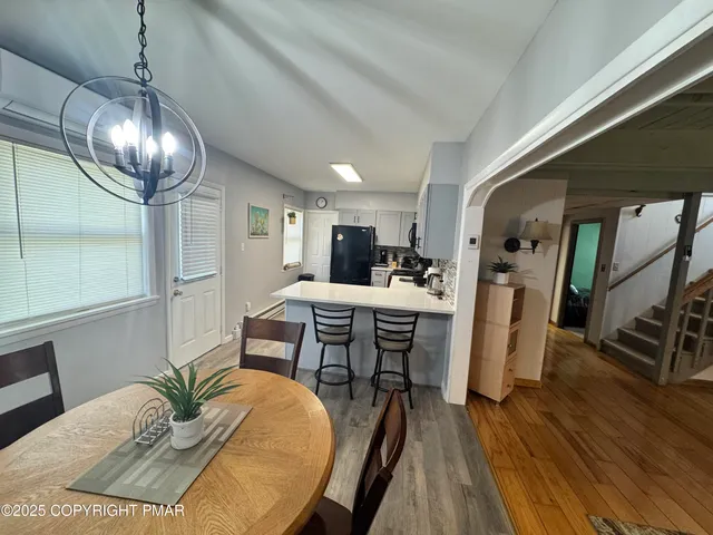 a dining room with furniture a chandelier and wooden floor