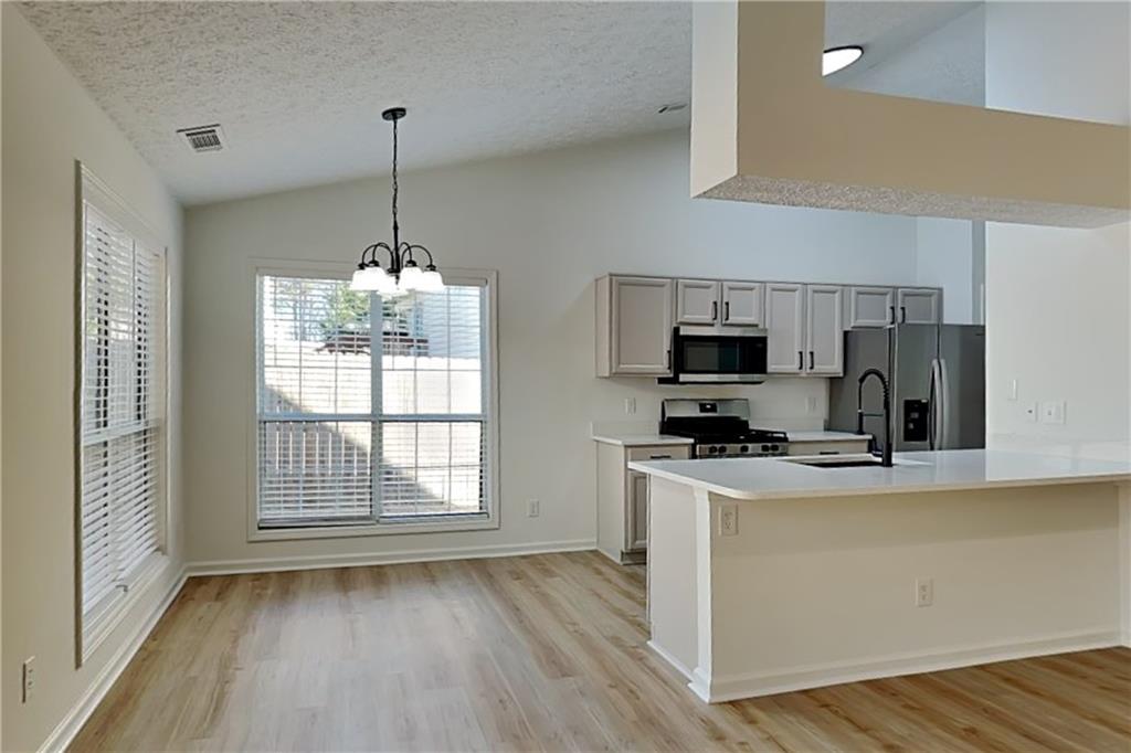 3616 Hollyhock Way Northwest Kennesaw, GA 30152 - Photo 5 of 18 a kitchen that has a microwave a stove and a wooden floors