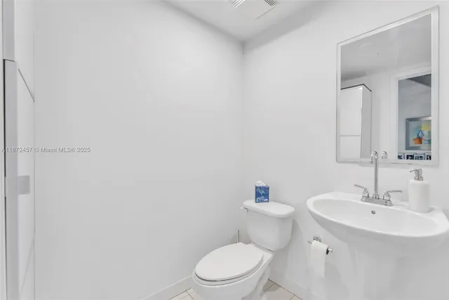 a bathroom with a sink a toilet and mirror