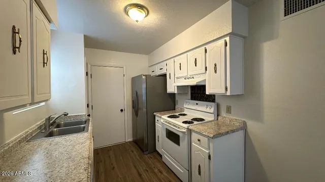 a kitchen with a refrigerator stove and white cabinets