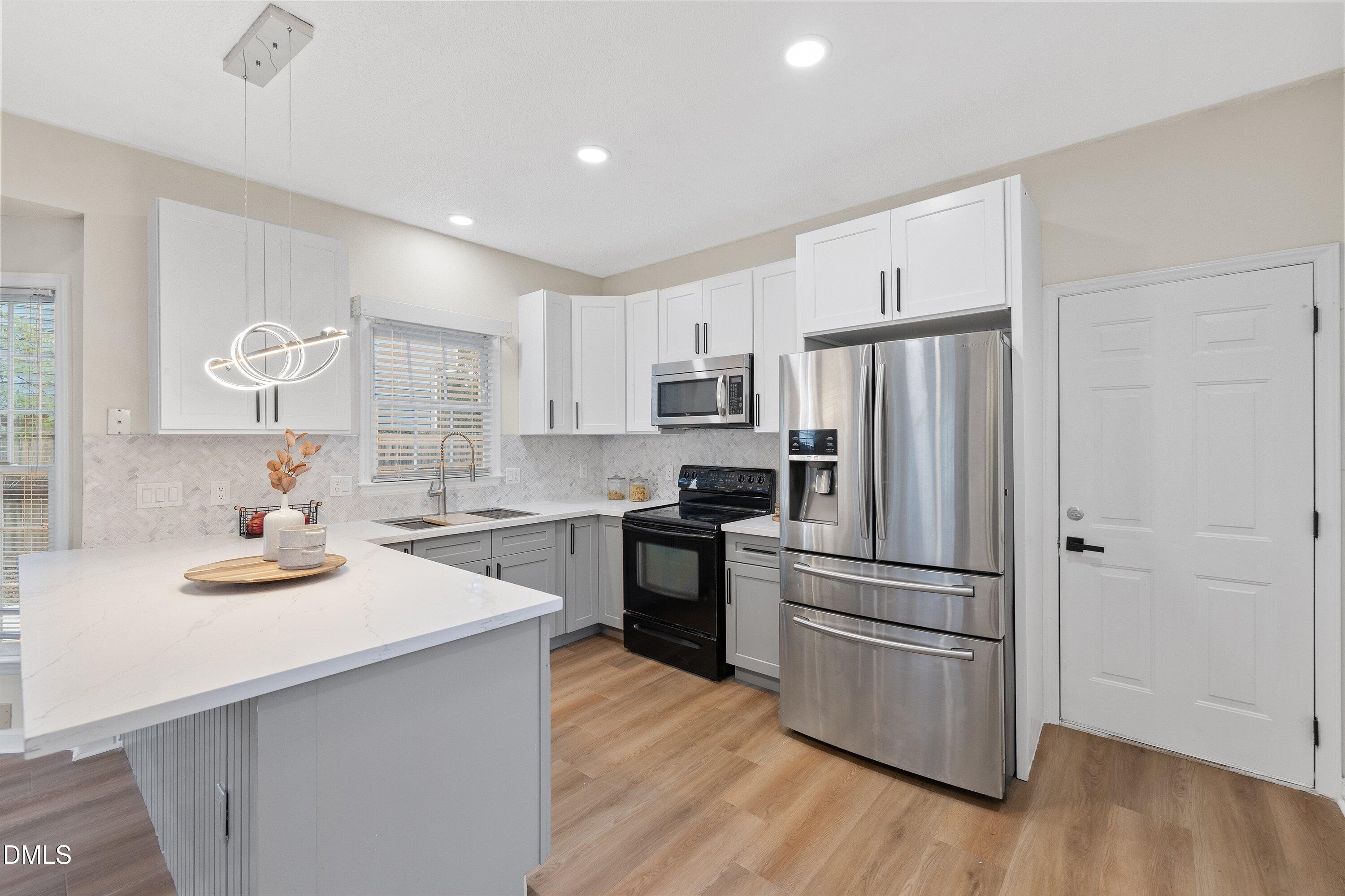 2517 Birchford Court Raleigh, NC 27604 - Photo 27 of 63 a kitchen with a refrigerator a stove cabinets and wooden floor