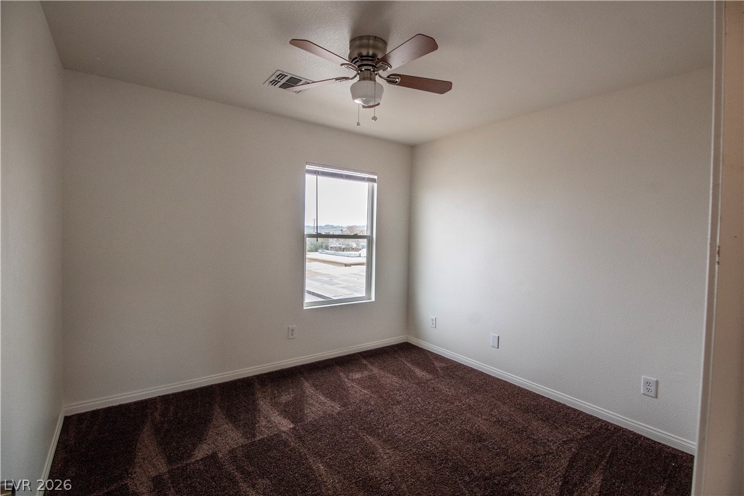 119 West Victory Road Henderson, NV 89015 - Photo 19 of 26 A quiet bedroom featuring plush carpeting and a large window offers a serene view.