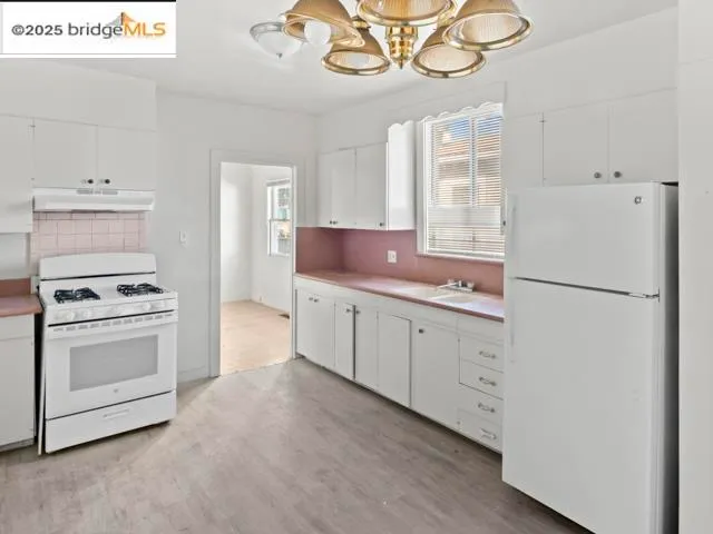 a kitchen with cabinets stainless steel appliances and wooden floor