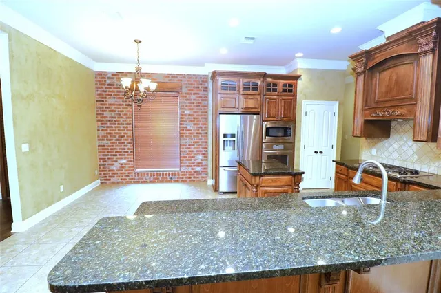 a kitchen with stainless steel appliances granite countertop a sink and a granite counter tops
