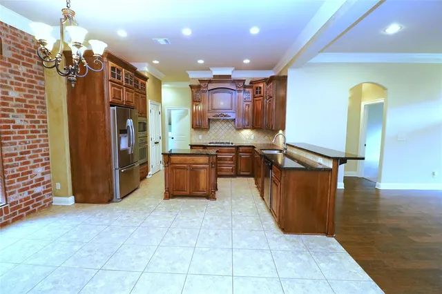 a kitchen with stainless steel appliances granite countertop a refrigerator and a sink