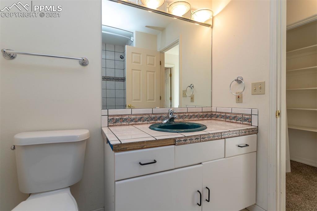 4440 Prairie Street Cascade, CO 80809 - Photo 13 of 38 a bathroom with a granite countertop sink a toilet and a mirror
