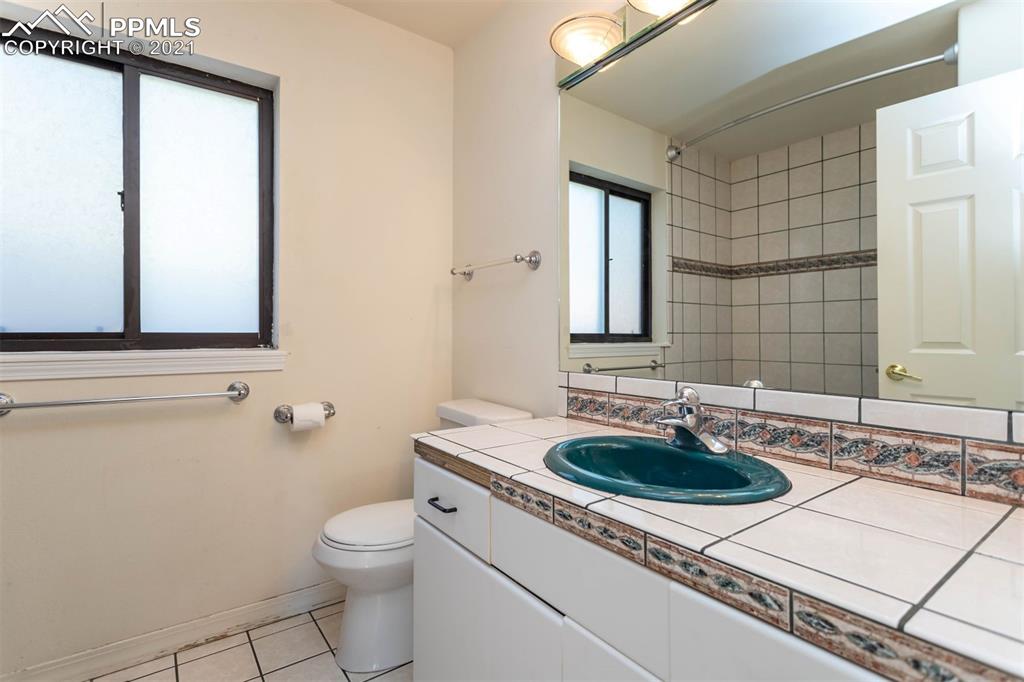 4440 Prairie Street Cascade, CO 80809 - Photo 14 of 38 a bathroom with a sink a toilet and mirror