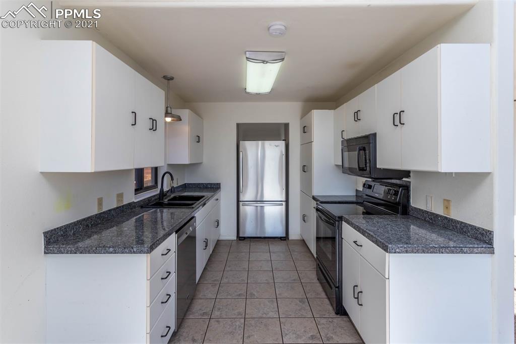 4440 Prairie Street Cascade, CO 80809 - Photo 19 of 38 a kitchen with granite countertop a sink dishwasher stove and refrigerator