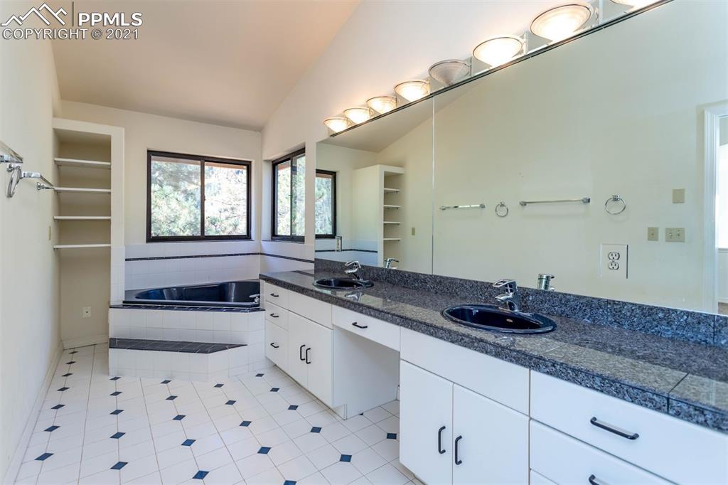 4440 Prairie Street Cascade, CO 80809 - Photo 23 of 38 a bath room with a sink and a large mirror