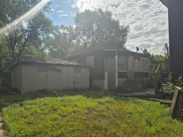 a view of backyard with plants and wooden fence