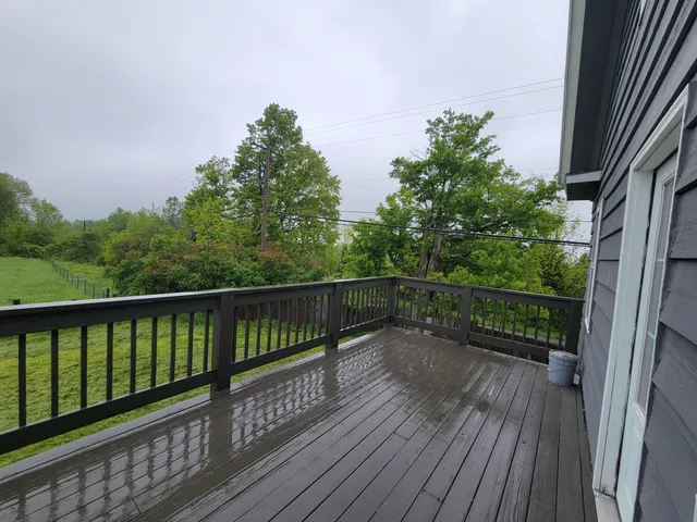 a view of balcony with wooden floor and fence