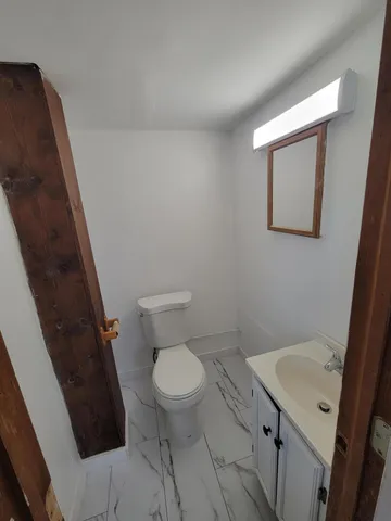 a white toilet sitting next to a white sink and vanity