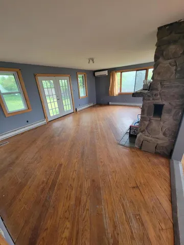 wooden floor in an empty room with a window
