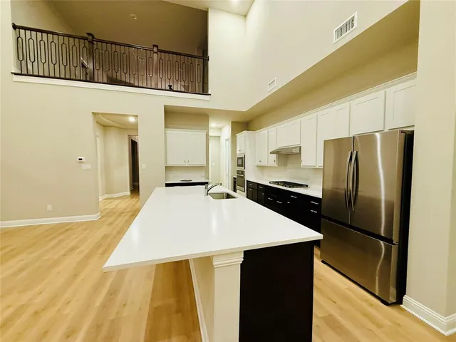 a kitchen with stainless steel appliances a refrigerator and a stove top oven