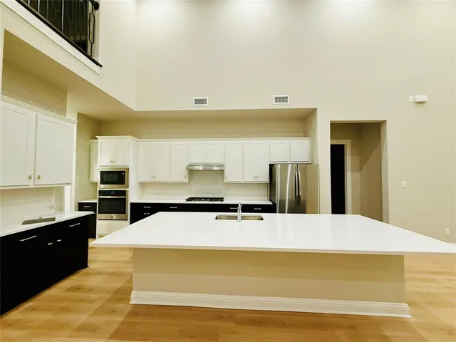 a kitchen with stainless steel appliances kitchen island sink refrigerator and stove