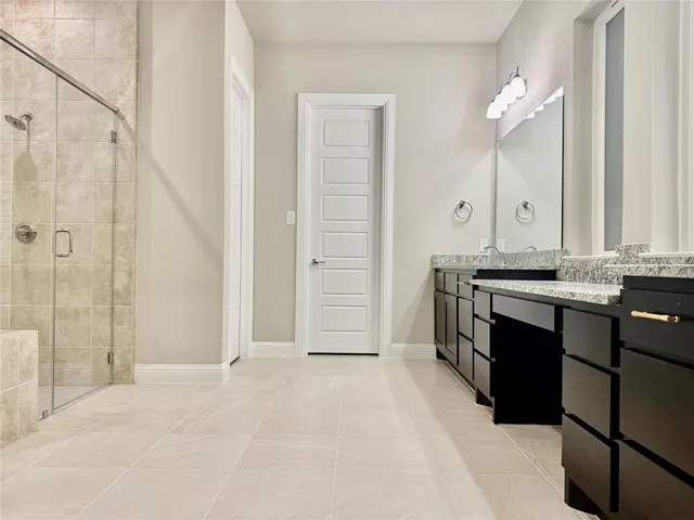 a spacious bathroom with a granite countertop sink a mirror and a bathtub