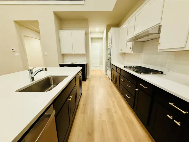 a kitchen with stainless steel appliances a sink stove and cabinets