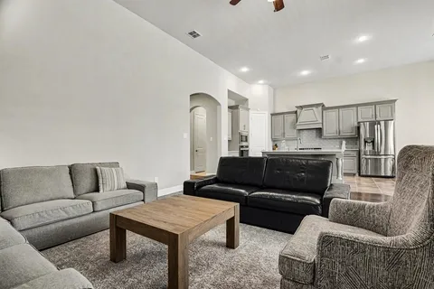 a living room with furniture and kitchen view