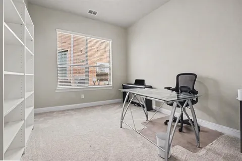 a view of a workspace with furniture and a window