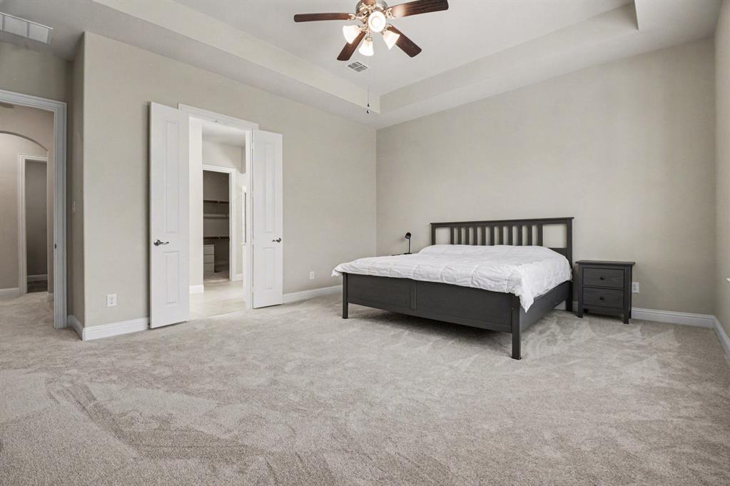 3323 Royal Ridge Drive Rockwall, TX 75087 - Photo 15 of 37 a spacious bedroom with a bed and ceiling fan