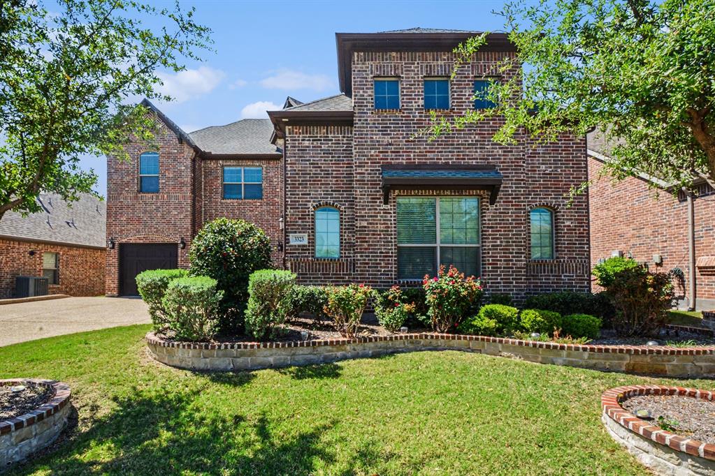 3323 Royal Ridge Drive Rockwall, TX 75087 - Photo 2 of 37 a front view of a house with a yard and potted plants