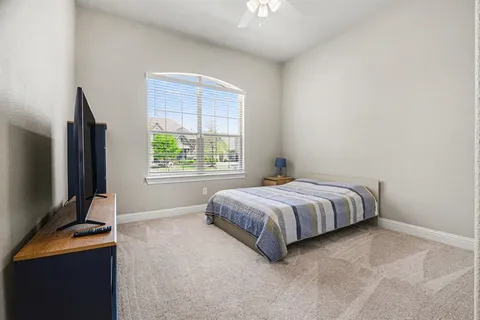 a bedroom with a bed tv and window