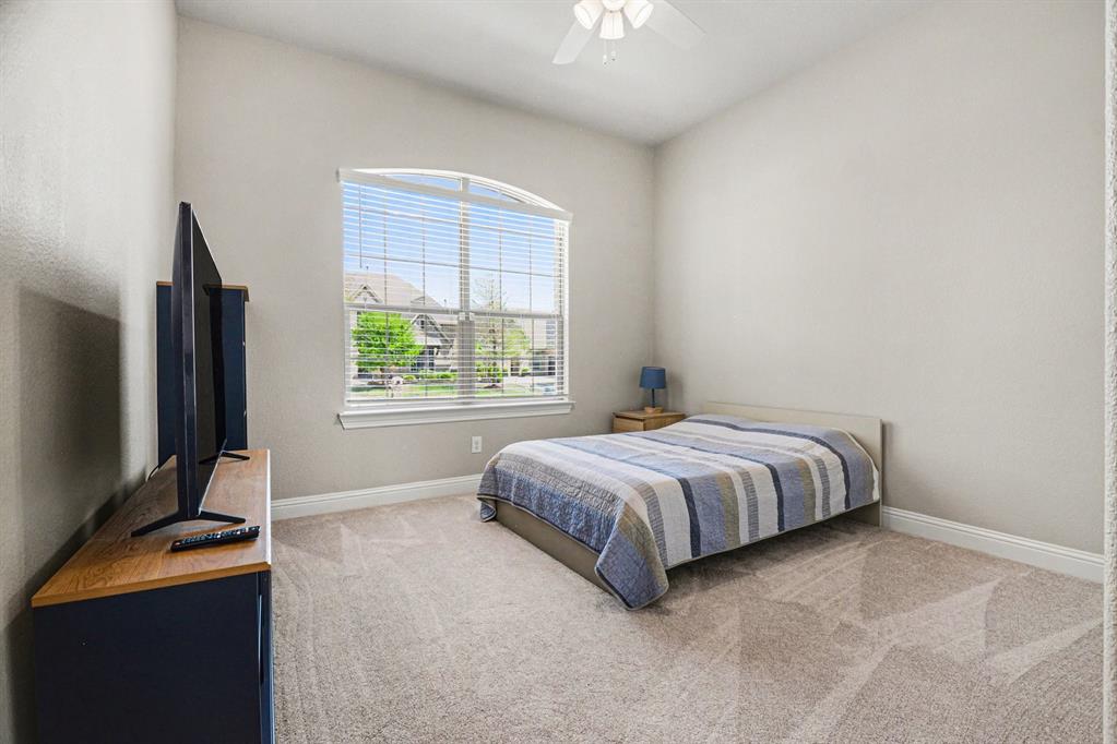 3323 Royal Ridge Drive Rockwall, TX 75087 - Photo 21 of 37 a bedroom with a bed tv and window