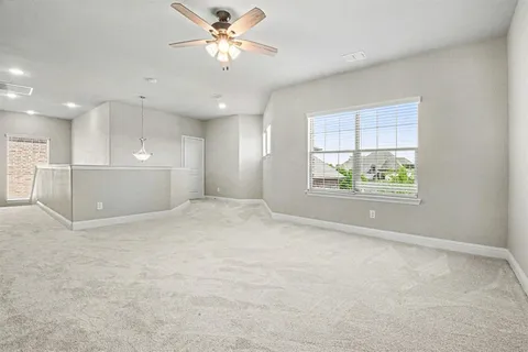 an empty room with windows and ceiling fan