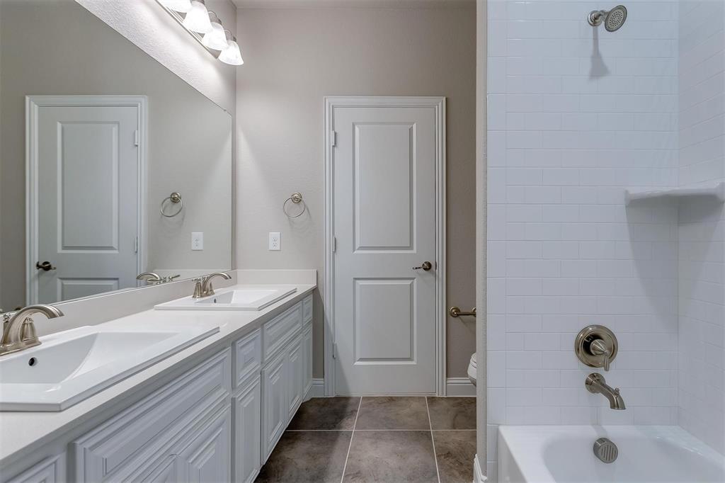 3323 Royal Ridge Drive Rockwall, TX 75087 - Photo 24 of 37 a bathroom with a double vanity sink a mirror and a bathtub