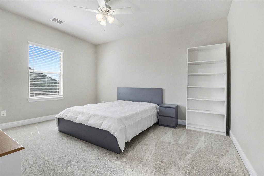 3323 Royal Ridge Drive Rockwall, TX 75087 - Photo 28 of 37 a bedroom with a bed and a chandelier