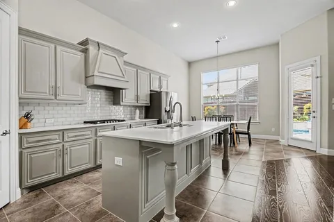 a kitchen with kitchen island granite countertop a sink stove and cabinets