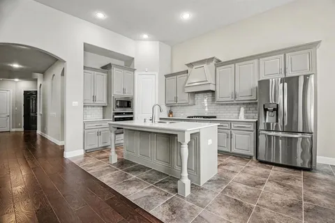 a kitchen with stainless steel appliances a refrigerator sink and cabinets
