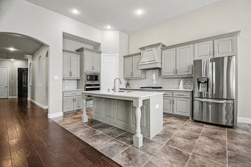 3323 Royal Ridge Drive Rockwall, TX 75087 - Photo 5 of 37 a kitchen with stainless steel appliances a refrigerator sink and cabinets