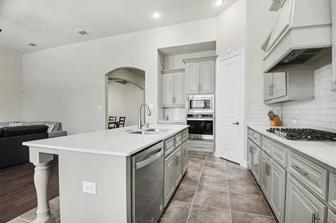 a kitchen with a sink stove and cabinets