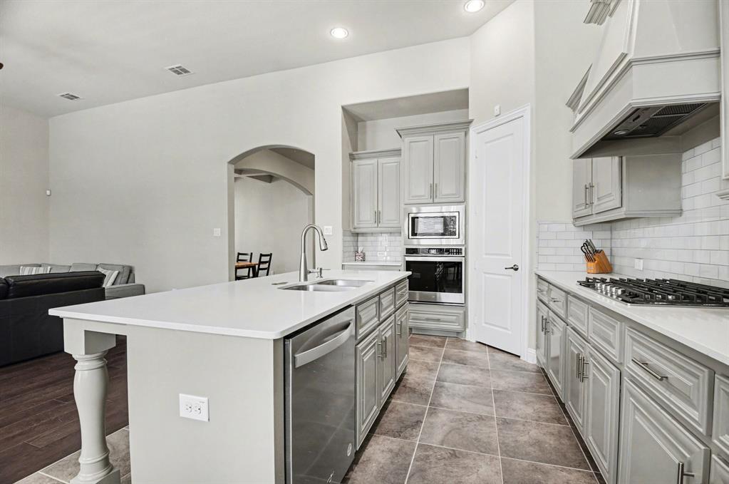 3323 Royal Ridge Drive Rockwall, TX 75087 - Photo 7 of 37 a kitchen with a sink stove and cabinets