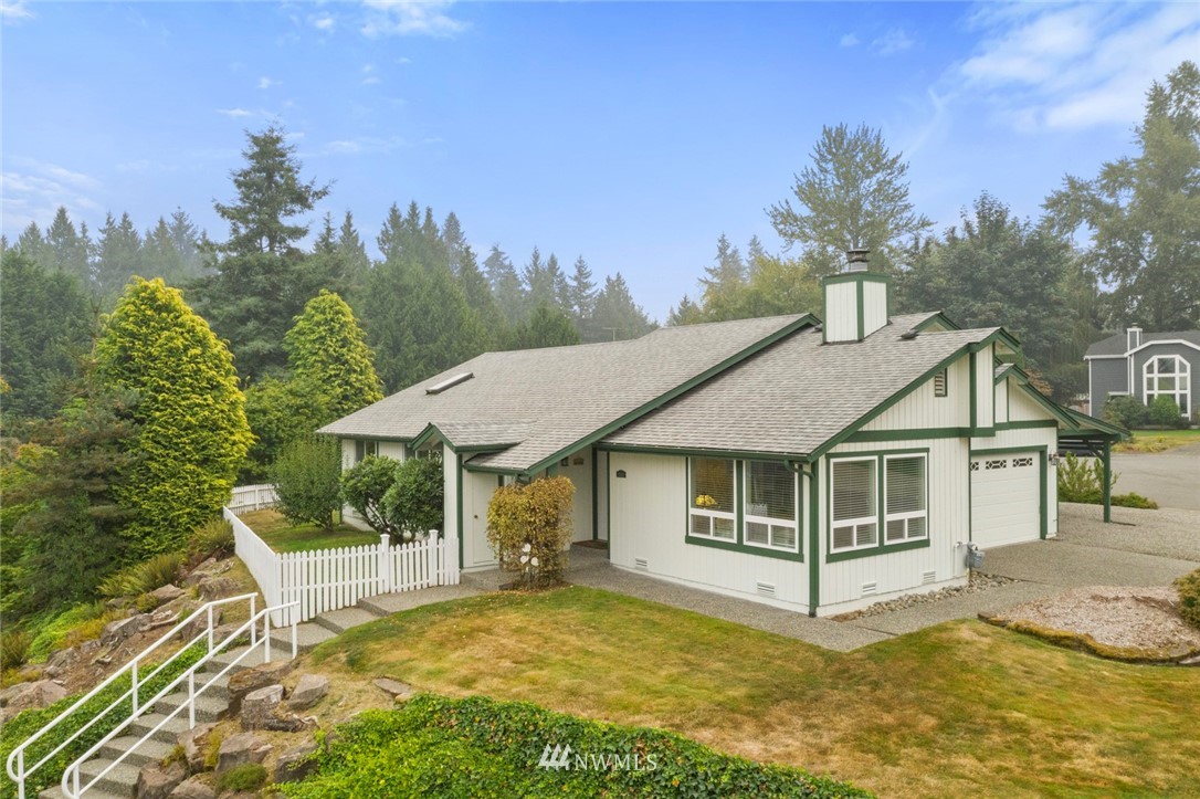 23513 22nd Avenue Southeast Bothell, WA 98021 - Photo 1 of 33 a white house with a large pool and lawn chairs next to a yard