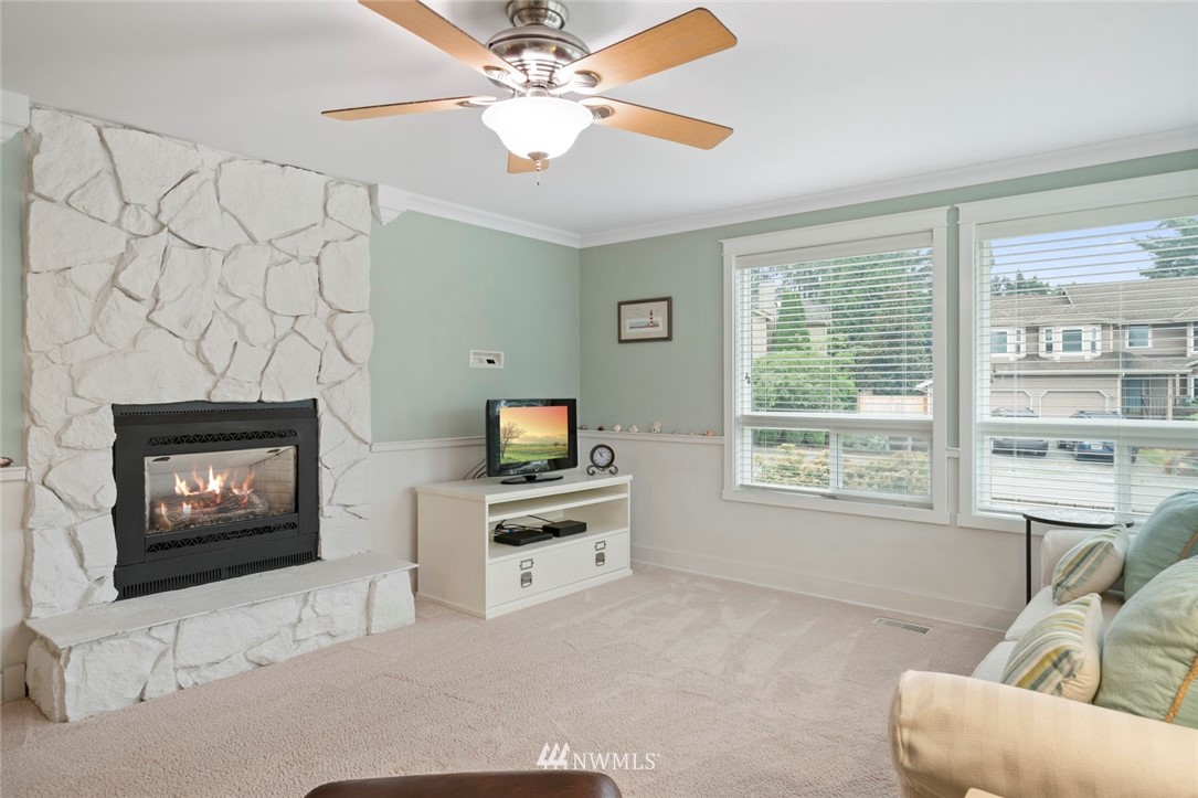 23513 22nd Avenue Southeast Bothell, WA 98021 - Photo 9 of 33 a living room with furniture a flat screen tv and a fireplace