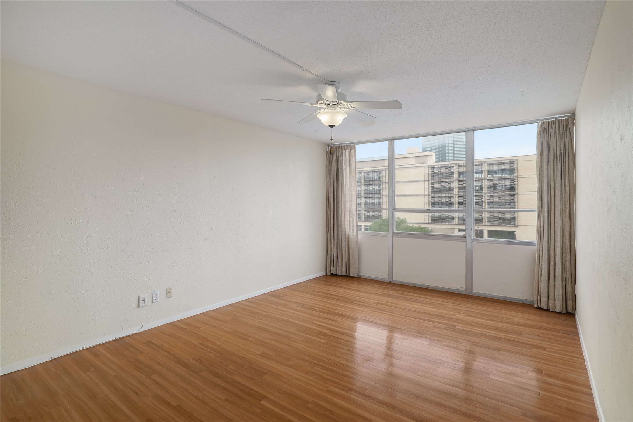 1800 Lavaca Street, Unit A508 Austin, TX 78701 - Photo 14 of 25 This room features laminate floors, lots of natural light, and a ceiling fan