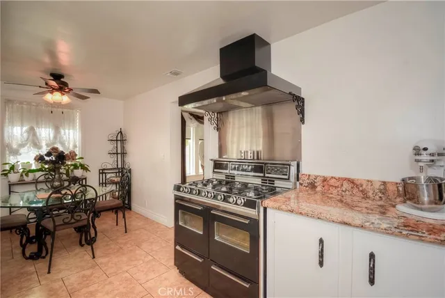 a dining room with furniture potted plants and wooden floor