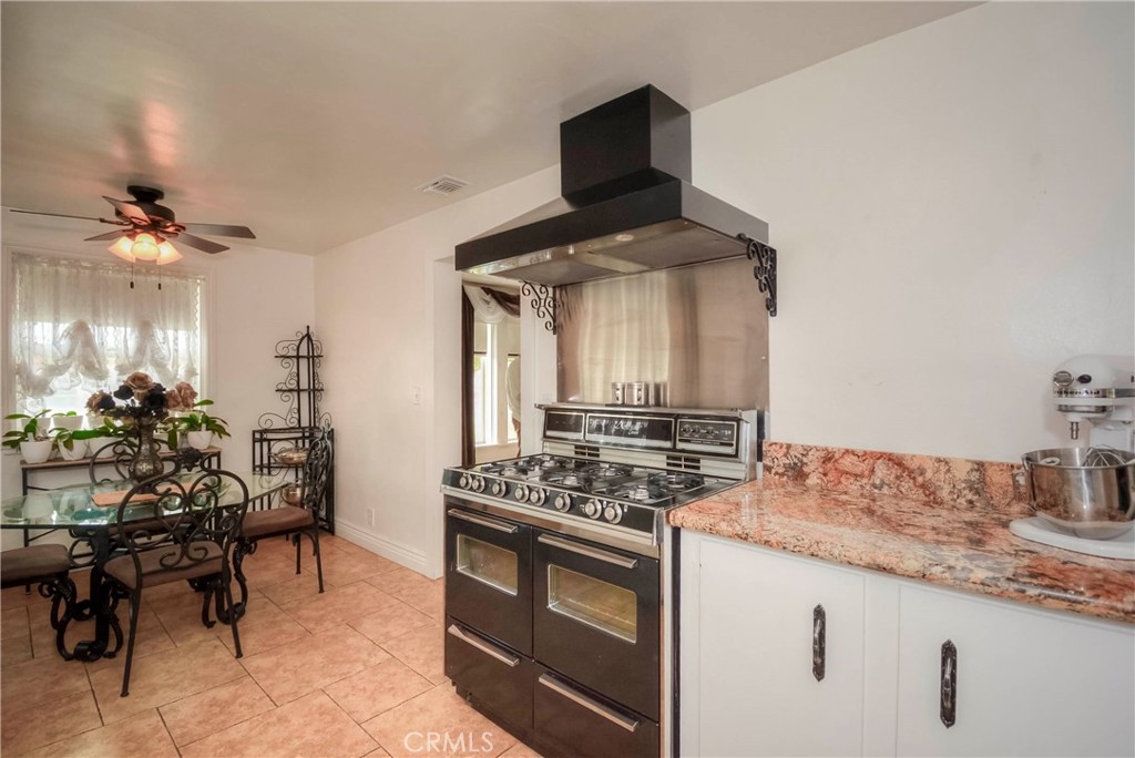 962 West 41st Street San Bernardino, CA 92407 - Photo 5 of 15 a kitchen with stainless steel appliances a stove a table and chairs