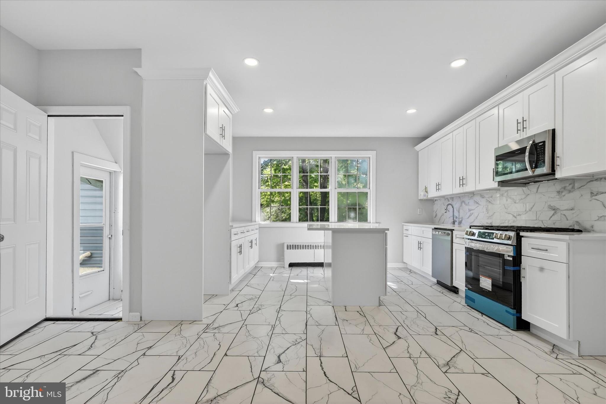 a view of kitchen with stainless steel appliances granite countertop a stove a sink and a refrigerator