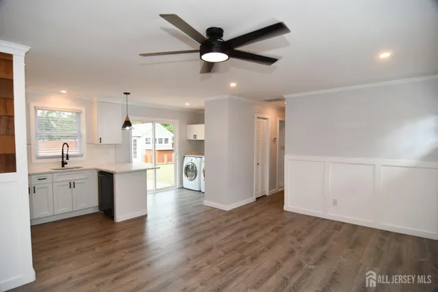 a open kitchen with white cabinets and wooden floor