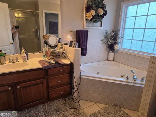 a bathroom with a tub sink and mirror